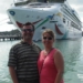 a man and woman standing in front of a cruise ship
