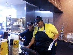 a couple of people standing in a kitchen