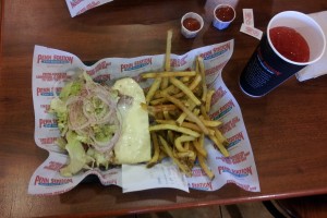 a sandwich and fries on a paper wrapper