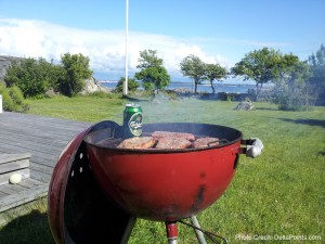 a red grill with meat and beer in it