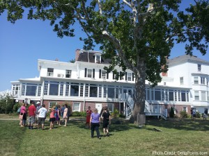 a group of people standing in front of a large white house