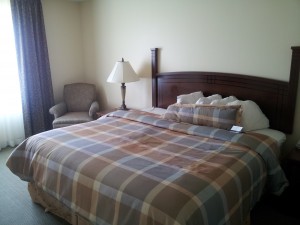 a bed with a lamp and a chair