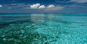 a blue ocean with clouds in the sky