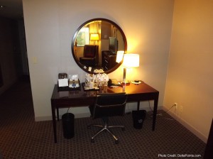 a desk with a mirror and a chair