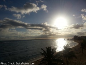 a sun shining over a body of water