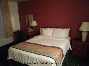 a hotel room with a bed and a lamp