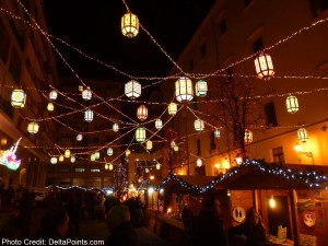 a group of people walking down a street with lanterns