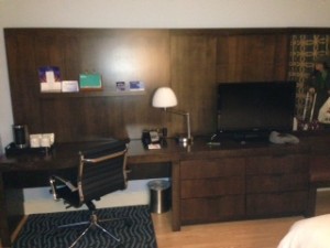 a desk with a lamp and a chair