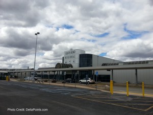 a building with a parking lot and clouds in the sky