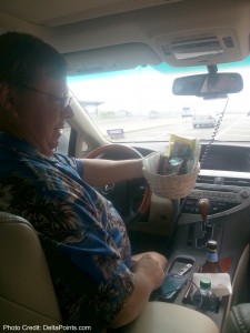a man in a car holding a basket of food