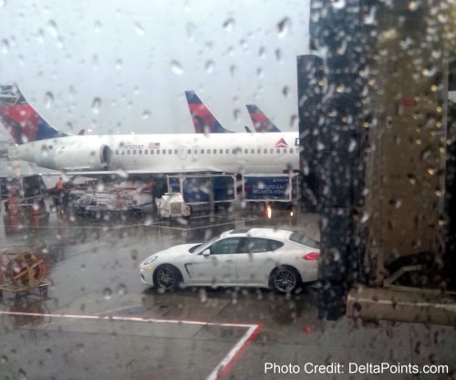 A Porsche is seen outside Delta Air Lines jets.