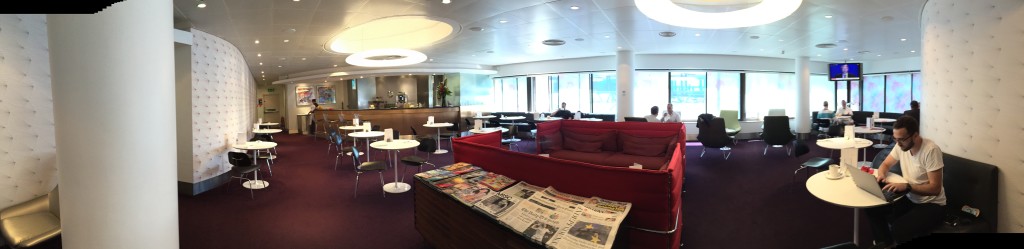 a room with a red couch and newspaper on the table