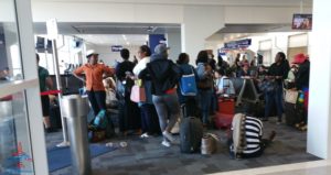 folks sitting down and taking off shoes in boarding area dfw airport renespoints blog