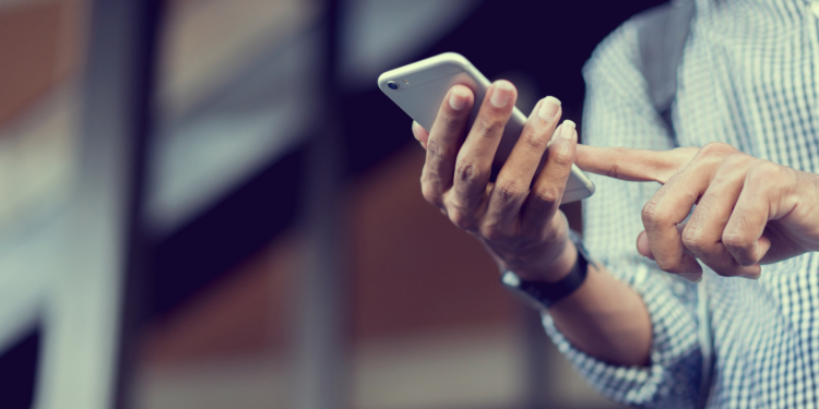 close up traveler backpacker man hand holding smartphone for checking flight online or search information on browser website about plan trip at destination , lifestyle concept