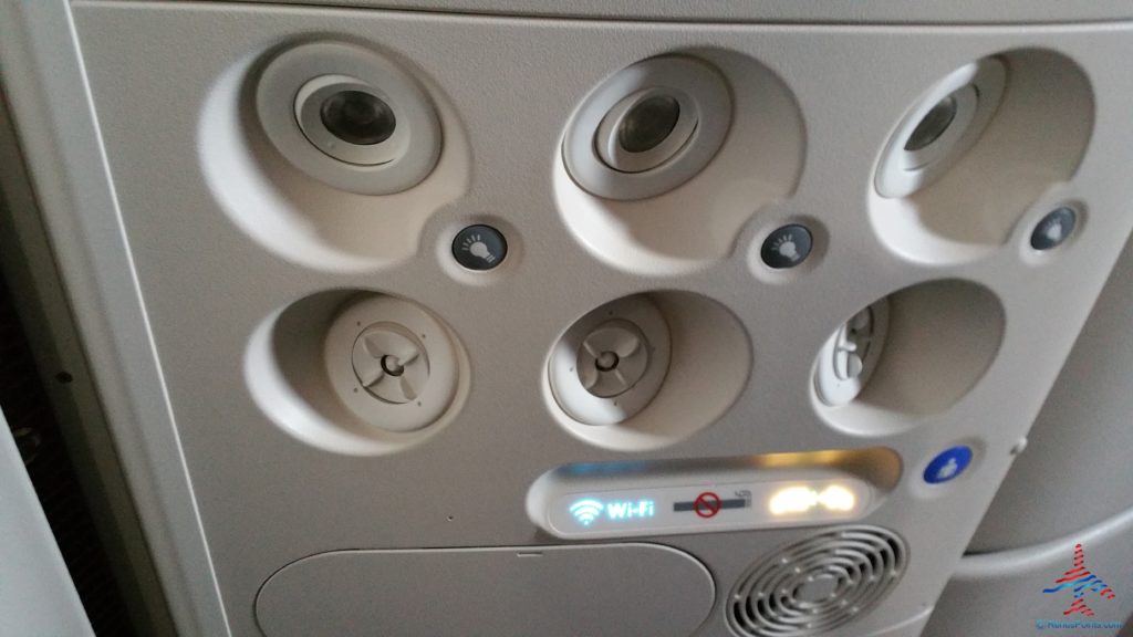 a ceiling with speakers and a sign