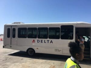 a white bus with people standing in front of it