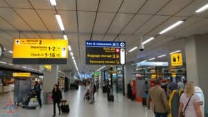 people in an airport with signs and luggage