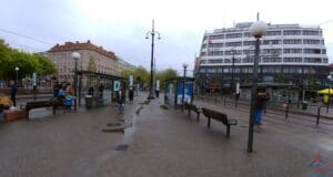 a city street with benches and a building