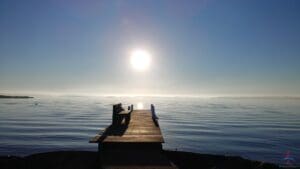 a dock with a bench on the edge of the water