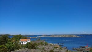 a house on a hill next to a body of water