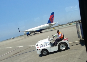 a man driving a small vehicle on a runway