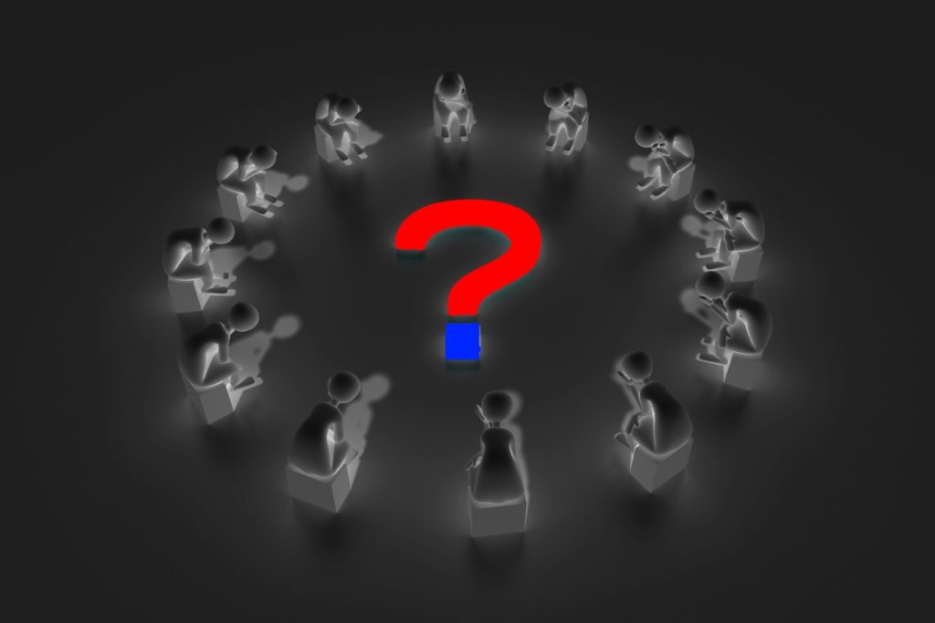 a group of people sitting in a circle with a question mark in the middle