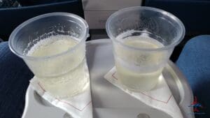 two plastic cups of liquid on a white plate