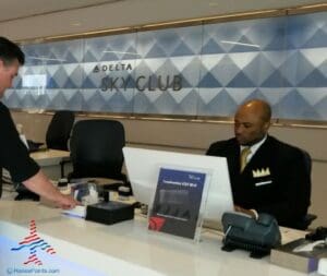 a man in a suit and tie talking to a man at a desk