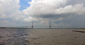 a bridge over water with clouds in the sky