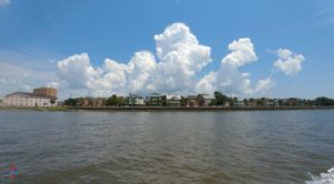 a body of water with buildings and clouds in the sky