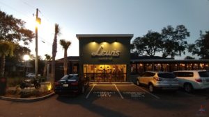 a building with a sign and cars parked in front of it