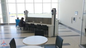 a room with a white wall and tables and chairs
