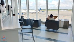 a man sitting in a chair in a room with windows
