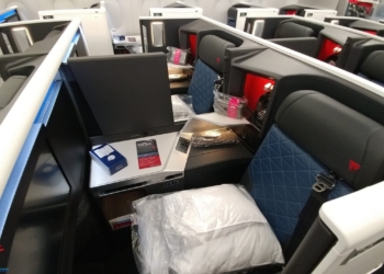 a seat with a white pillow and a blue cushion on it