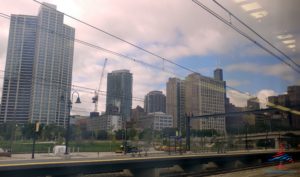 a train tracks with a city skyline in the background