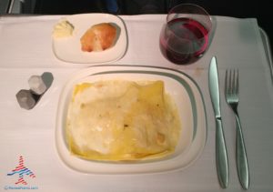 food on a plate with a glass of wine