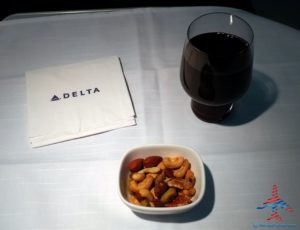 a bowl of nuts and a glass of wine