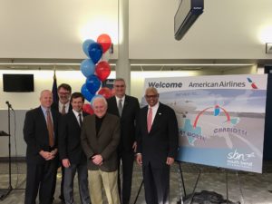 a group of men standing in front of a sign