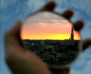 a hand holding a circular lens