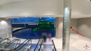 a group of people walking up a escalator