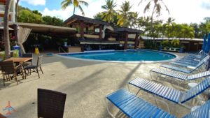 a pool with chairs and a building