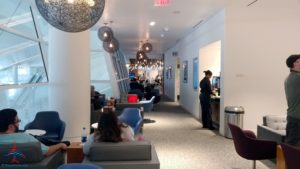 a long hallway with people sitting on chairs