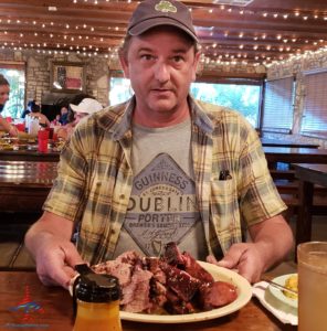 a man sitting at a table with a plate of food