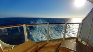 a deck with a chair and a railing on a boat