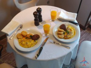 a table with plates of food and a glass of juice