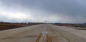 an airplane flying over a runway