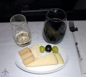 a plate of cheese grapes and wine glasses