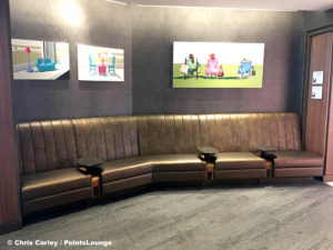 Artwork is displayed over tables and chairs at the Delta Sky Club Austin airport lounge at Austin-Bergstrom International Airport (AUS) in Austin, Texas. Photo © Chris Carley / PointsLounge