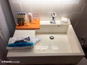 Sink and toiletries are seen in the bathroom of a room at the Stewart Hotel New York City in midtown Manhattan, NY.