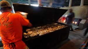 a man in an orange shirt putting food in a large black box